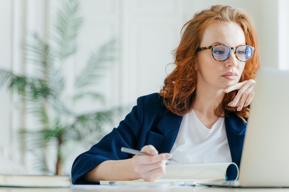 Young professional woman taking an online course after getting laid off from her job