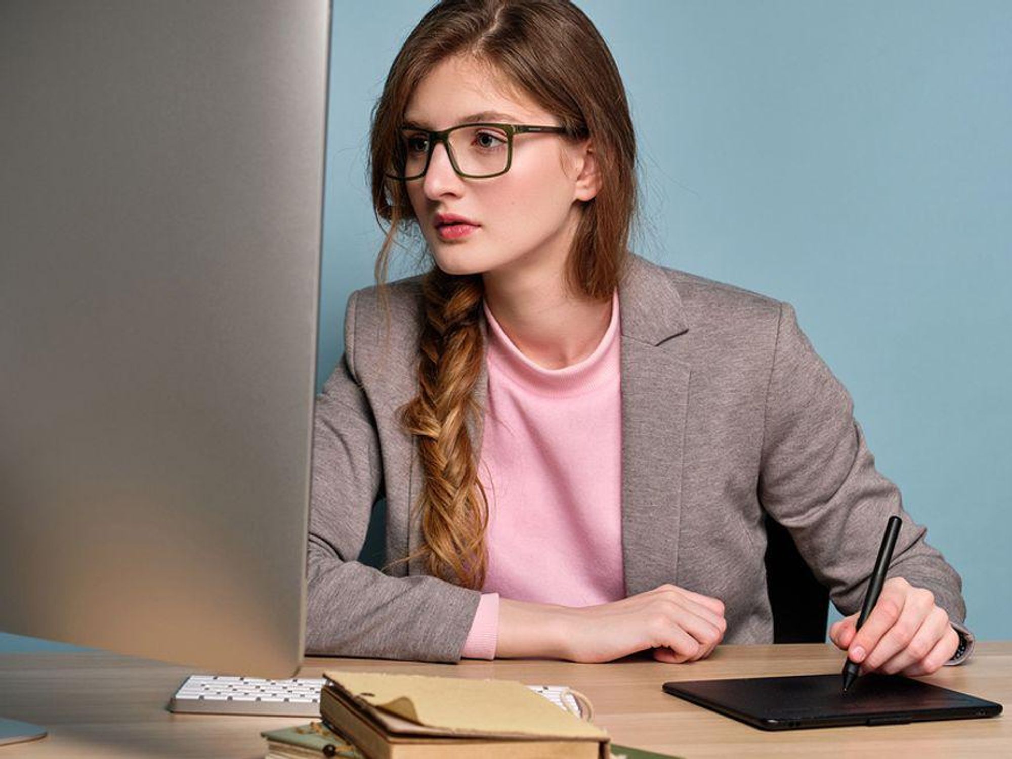 Young professional woman working on her cover letter on a computer and learning to avoid cover letter mistakes.