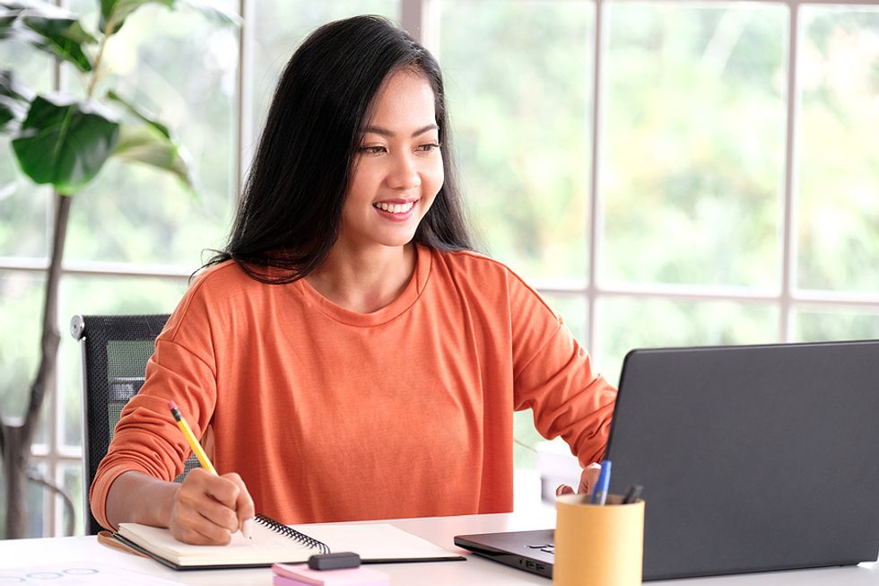 Young professional works on optimizing her LinkedIn profile on her laptop