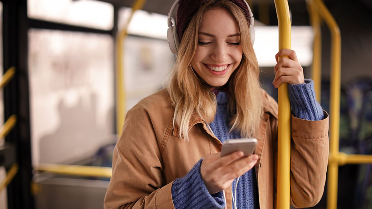 Young woman listens to podcast episodes while on the bus