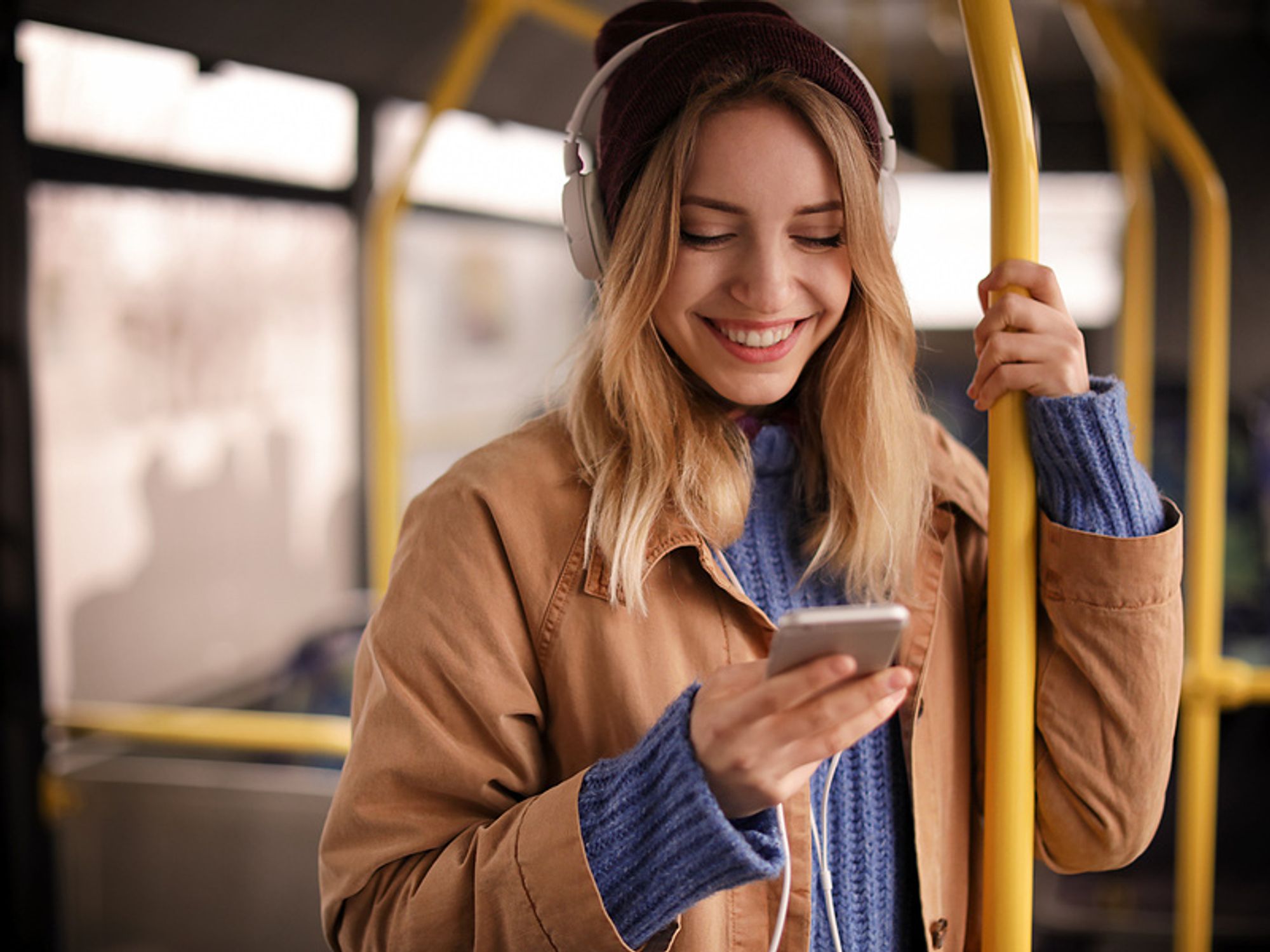Young woman listens to podcast episodes while on the bus