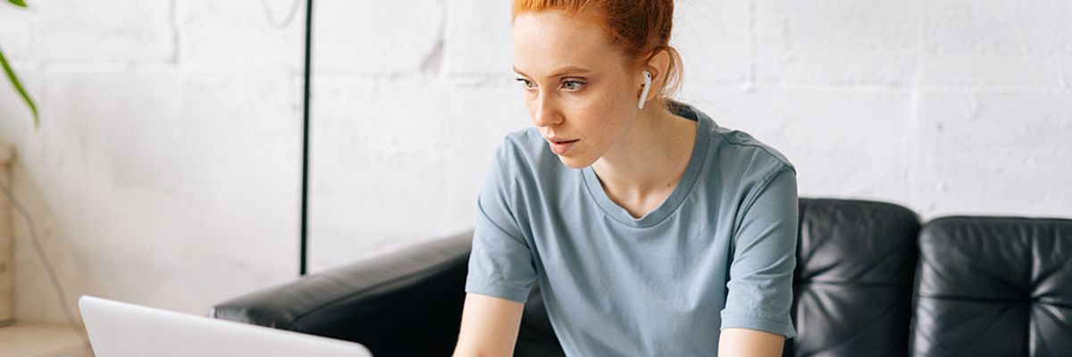 Young woman listens to podcast episodes while working