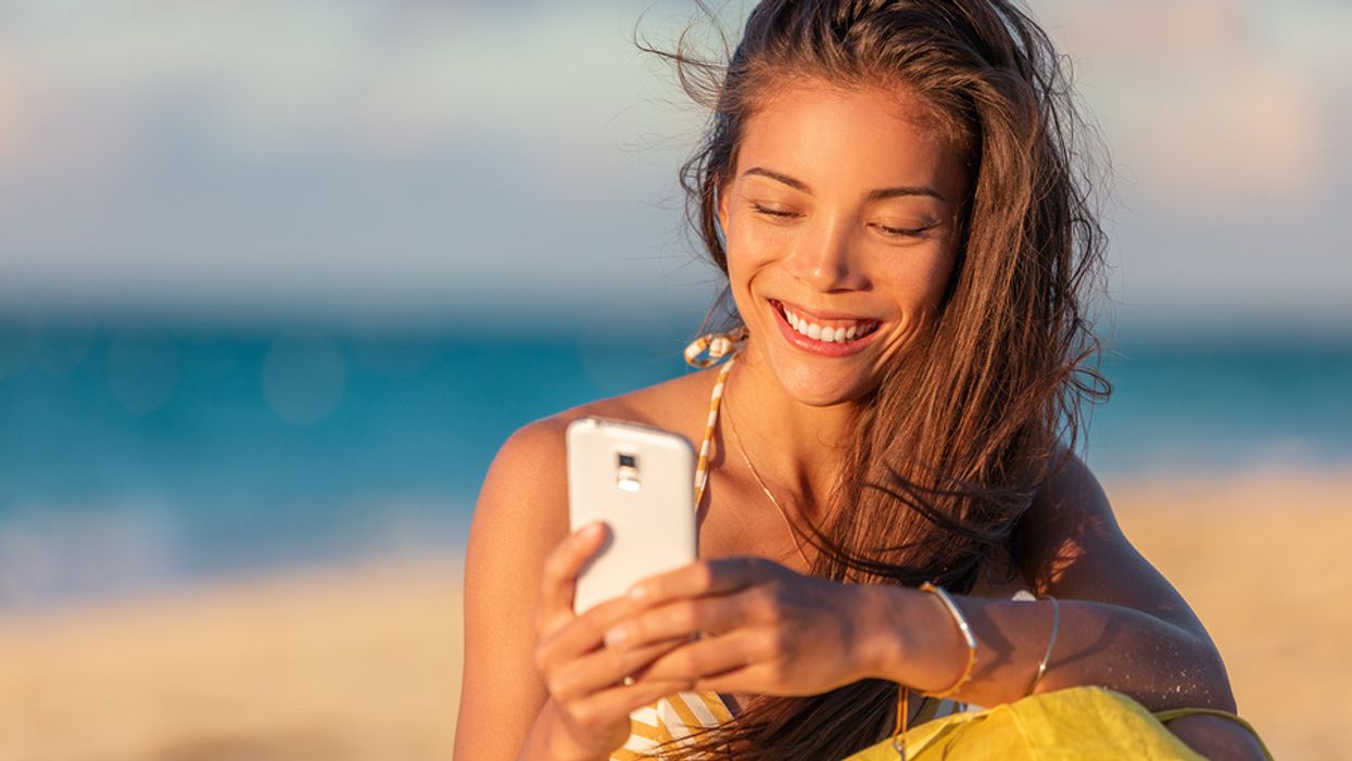 Young woman networks briefly on her phone while on summer vacation