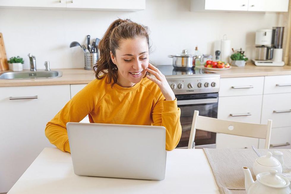 Young woman on laptop happy while working from home
