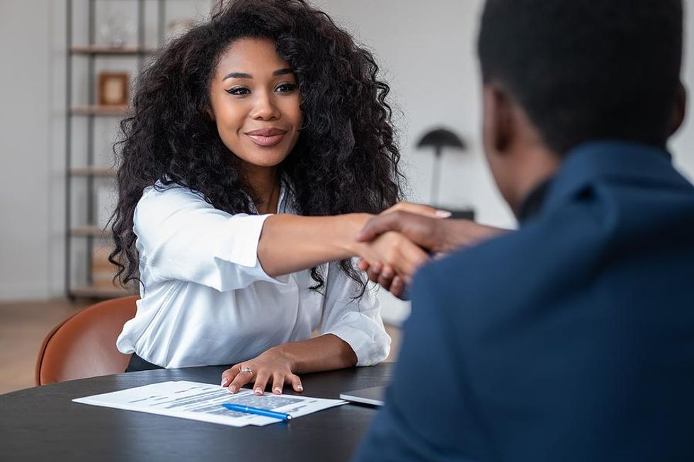 Young woman shakes hands with the hiring manager before a job interview